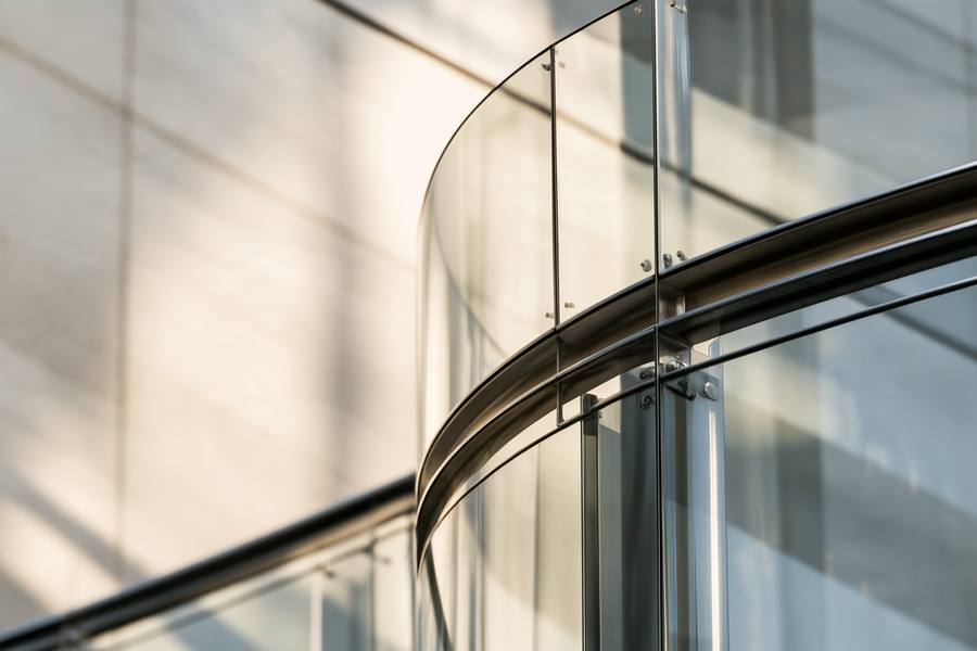 Curved glass facade with a steel rail